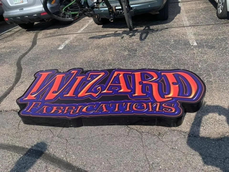 Dimensional red and purple Wizard Fabrications sign ready for installation